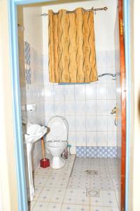 łazienka z toaletą i umywalką w obiekcie Enchante Suites Kigali w mieście Kigali