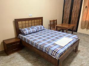 um quarto com uma cama, uma mesa e uma cadeira em CHAMBRES PRIVEE-APPARTEMENT VUE SUR MER em Dakar