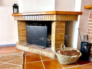 a brick fireplace in a living room with a basket at Jacuzzi en Benaocaz by CadizTime Apartments in Benaocaz