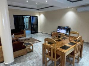 een woonkamer met een tafel en een bank bij CHAMBRES PRIVEE-APPARTEMENT VUE SUR MER in Dakar