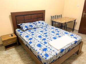 um quarto com uma cama com um edredão azul e branco em CHAMBRES PRIVEE-APPARTEMENT VUE SUR MER em Dakar