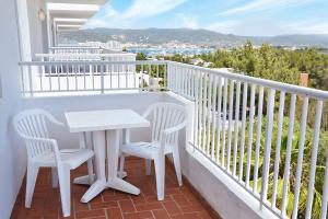 einen weißen Tisch und zwei Stühle auf dem Balkon in der Unterkunft Hotel Apartamentos Vibra Monterrey in Bucht von San Antonio