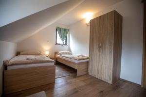een slaapkamer met 2 bedden en een kast op zolder bij Apartmani Lara Modruš-Kuća za odmor in Modruš