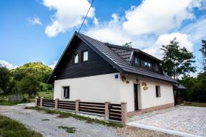 een huis met een zwart dak bij Apartmani Lara Modruš-Kuća za odmor in Modruš