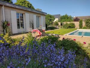einen Garten mit lila Blumen und einem Pool in der Unterkunft Le Chêne Olivet in Olivet