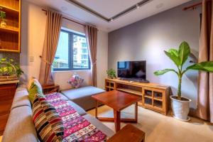 uma sala de estar com um sofá e uma televisão em Taian Hotel & Apartment em Da Nang