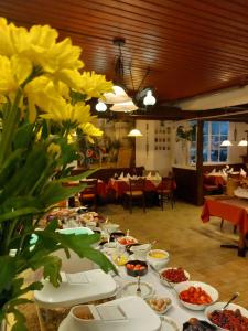 una mesa larga con platos de comida y flores amarillas en Hotel Schloßschenke, en Idar-Oberstein