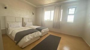 um quarto branco com uma cama grande e uma janela em Chambres luxueuses em Ouazzane