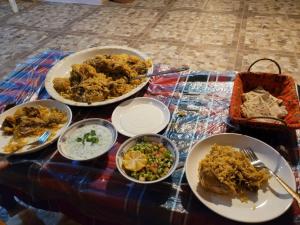 une table recouverte de assiettes et de bols de nourriture dans l'établissement Petra Glamour Hostel, à Taiyiba