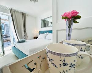 - une chambre avec un lit, 2 tasses et des fleurs sur une table dans l'établissement VILLA GIANNI - room VENEZIA - 4 stars, à Lovran