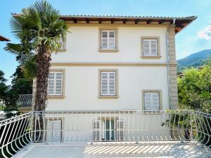 une maison avec un balcon et un palmier dans l'établissement VILLA GIANNI - room VENEZIA - 4 stars, à Lovran