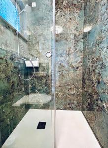 La salle de bains est pourvue d'une douche avec une porte en verre. dans l'établissement VILLA GIANNI - room VENEZIA - 4 stars, à Lovran