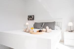 a white bedroom with a tray of food on a bed at Magnifico Apto. en Sueño Azul in Callao Salvaje +24 photos