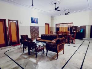 ein Wohnzimmer mit einem Sofa und Stühlen in der Unterkunft Royal Oaks Inn in Amritsar