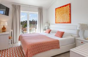 a white bedroom with a bed and a window at Boutique Hotel Casa do Outeiro - Arts & Crafts in Batalha