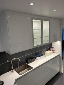 a kitchen with white cabinets and a sink at Lejlighed i København Vesterbro- Dybbølsgade in Copenhagen