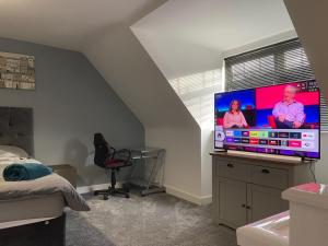 1 dormitorio con una gran TV de pantalla plana en una cómoda en Boothferry Park Lodge, en Hull