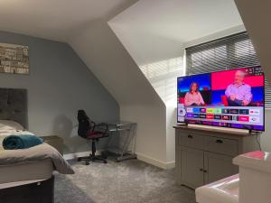 a bedroom with a large flat screen tv on a dresser at Boothferry Park Lodge in Hull