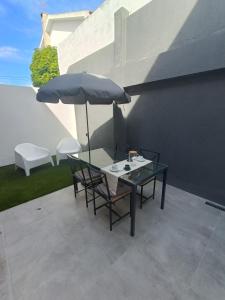 una mesa y sillas con una sombrilla en el patio en Casa Saudade, en Charneca
