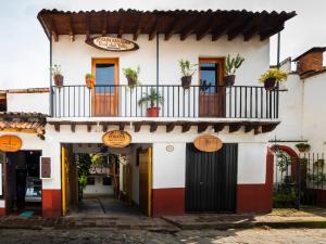 a building with a balcony with potted plants on it at Posada Real del Valle in Valle de Bravo +17 photos