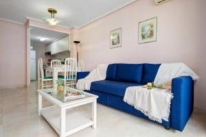 a living room with a blue couch and a table at Paradis Park Apartments in La Pineda +26 photos