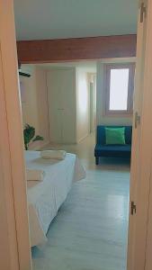 Habitación con cama y sofá azul en Apartamentos RyC, en Alcalá de Henares