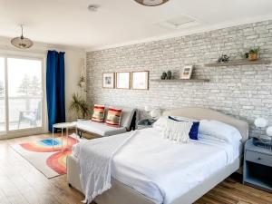 a bedroom with a bed and a brick wall at The Marmalade Motel in Port Dufferin