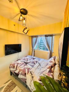 een slaapkamer met een bed, een tv en een raam bij * *P Fantastic 2BR Option for 8 in Iloilo City