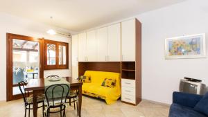 プーラにあるCasa Vacanze Mulvoni Aiosardegnaのリビングルーム(黄色のベッド1台、テーブル付)