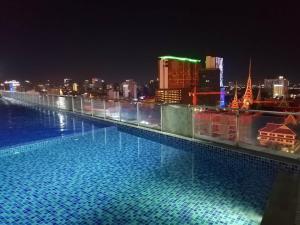 a large swimming pool on top of a building at night at ImPian 1BR homestay in Phnom Penh