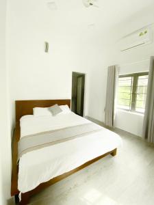 sypialnia z dużym białym łóżkiem w pokoju w obiekcie Hideaway Homestay w mieście Phong Nha