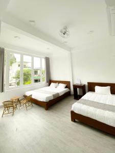 sypialnia z 2 łóżkami, stołem i krzesłami w obiekcie Hideaway Homestay w mieście Phong Nha