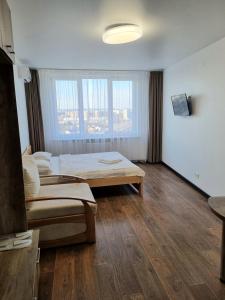 een slaapkamer met 2 bedden en een groot raam bij Apart Panorama in Lviv