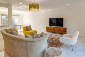 uma sala de estar com um sofá e uma televisão em Sunny Palm Springs Townhome with Pool Access! em Palm Springs