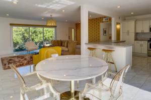 uma cozinha e sala de estar com uma mesa branca e cadeiras em Sunny Palm Springs Townhome with Pool Access! em Palm Springs