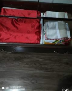 an open suitcase with red and white pillows on it at Didveli residenc in Bakuriani