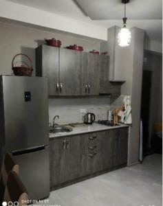 a kitchen with wooden cabinets and a stainless steel refrigerator at Didveli residenc in Bakuriani