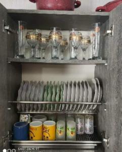 a shelf with cups and wine glasses on it at Didveli residenc in Bakuriani