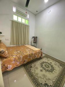 Schlafzimmer mit einem Bett, einem Fenster und einem Teppich in der Unterkunft De'Laman Homestay Unit 1 