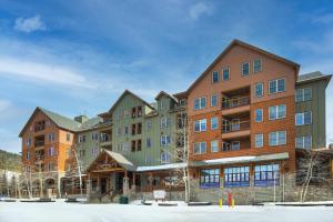 a large apartment building with snow on the ground at River Run Village by Keystone Resort in Keystone