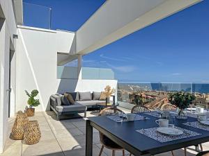 a patio with tables and chairs on a balcony at Via Celere 2329 Luxury apartment with Sea View in Casares
