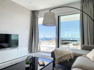 een woonkamer met een bank en een tv bij Via Celere 2329 Luxury apartment with Sea View in Casares