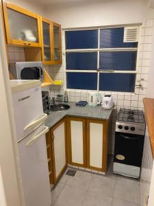 una pequeña cocina con nevera blanca y fregadero en Departamento en Recoleta en Buenos Aires