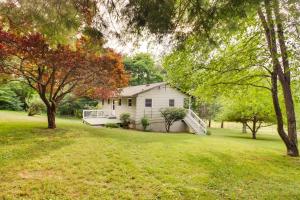 a white house in a field with trees at Cozy Nonny Cottage Near Appalachian Trail! in Vesuvius