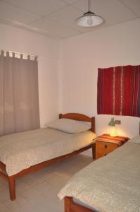 ein Schlafzimmer mit 2 Betten und einer Lampe auf einem Tisch in der Unterkunft Hostal Margaritas Torotoro in Torotoro