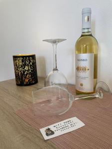 カリアリにあるSunset 221 Cagliariのワイン1本とワイングラス1杯(テーブルの上)