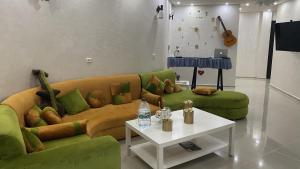 uma sala de estar com um sofá verde e uma mesa em Chambres luxueuses em Ouazzane