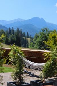 a hammock on a deck with mountains in the background at Apartamenty Hrube Niżne 23D in Zakopane