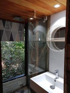 a bathroom with a sink and a mirror and a window at Area 4 eco cubes in Ella