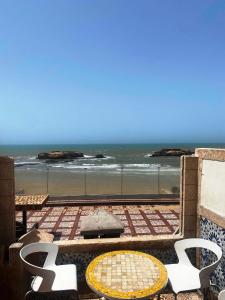d'un balcon avec une table et des chaises donnant sur l'océan. dans l'établissement RIAD Tamazouzt, à Essaouira
